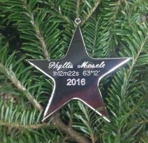 Star shaped ornament in Christmas tree has star name and coordinates