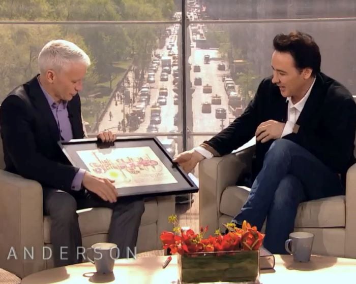 John Cusack receiving a name a star certificate from Andersen Cooper live on his show.