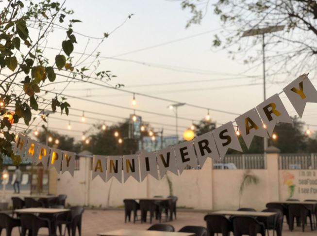 Happy Anniversary spelled out with flags across a back yard