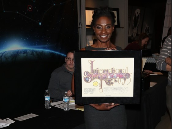 Adina porter holding his name a star certificate from starregistry.com