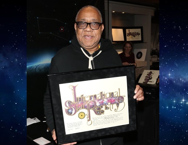 Barry Shabaka holding his name a star certificate from starregistry.com