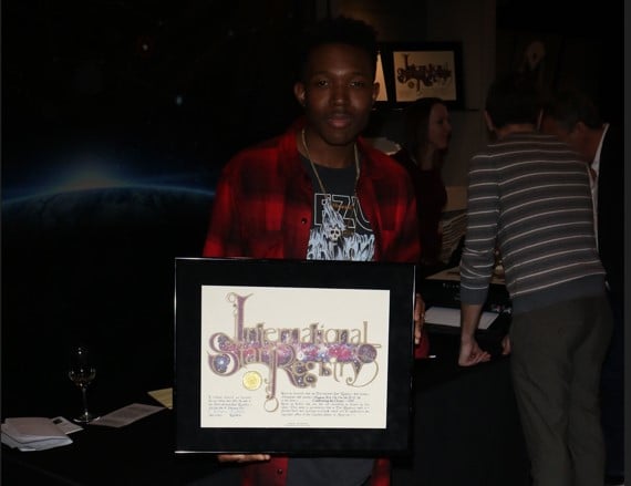 Denzel Whitaker holding his name a star certificate from starregistry.com