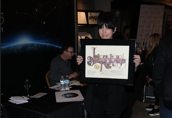 Diane Warren holding her name a star certificate from starregistry.com