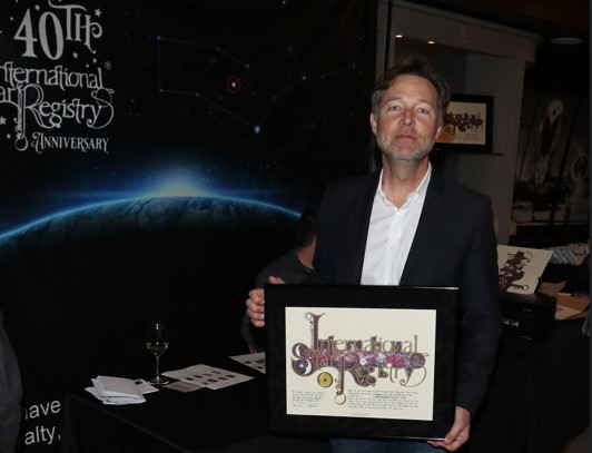 George Newbern holding his name a star certificate from starregistry.com