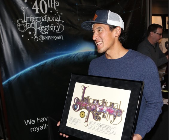 Jimmy Chin holding his name a star certificate from starregistry.com