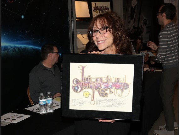 Mindy Sterling holding hername a star certificate from starregistry.com