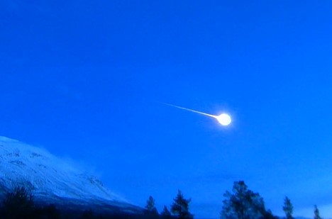 A meteor streaks through a blue sky over Norway