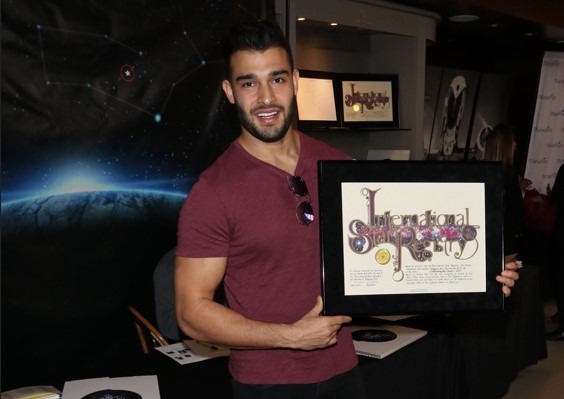 Sam Asghari holding his name a star certificate from starregistry.com