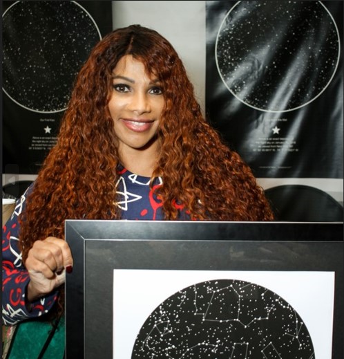 Sandra Denton (Pepa) holding a sky map from International Star Registry