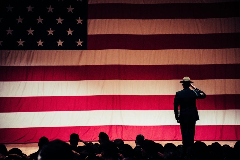 Soldiers saluting the American flag.