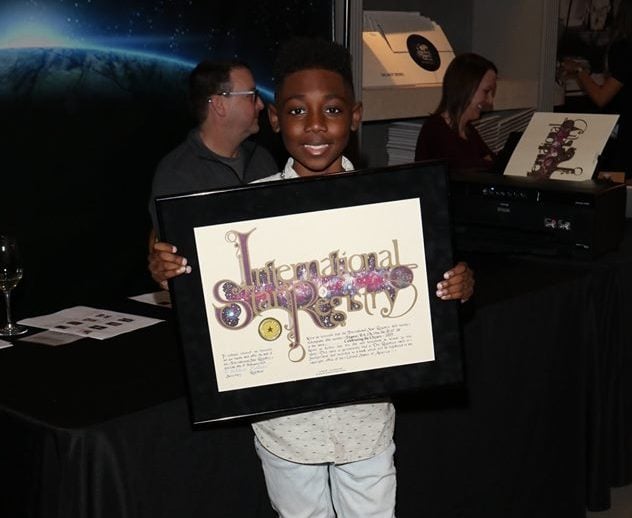 Christian Isaiah holding a star certificate from International Star Registry