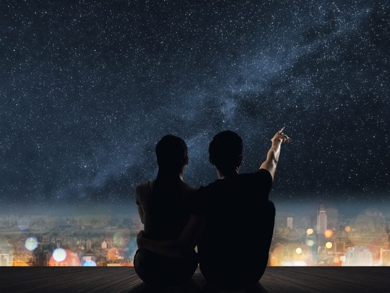 A couple sits under the stars