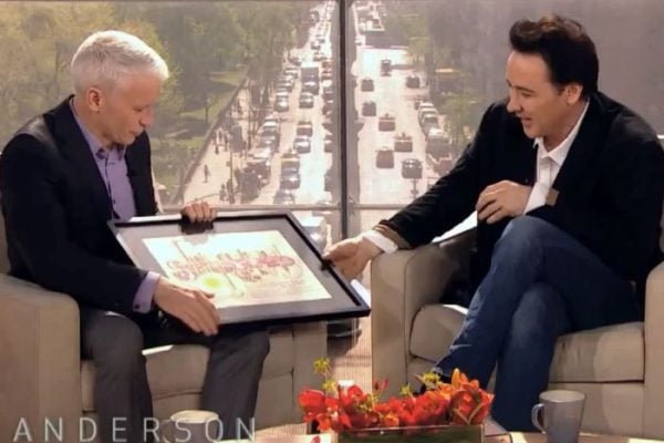 John Cusack receiving a name a star certificate from Andersen Cooper live on his show.