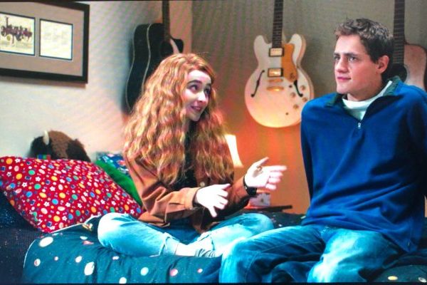 Couple sits on bed with Star Certificate above them