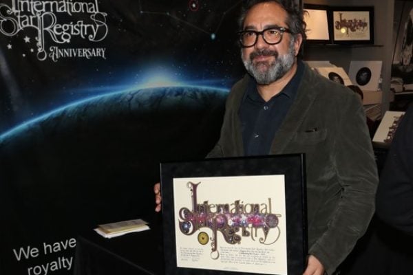 Eugenio Caballero holding his name a star certificate from starregistry.com