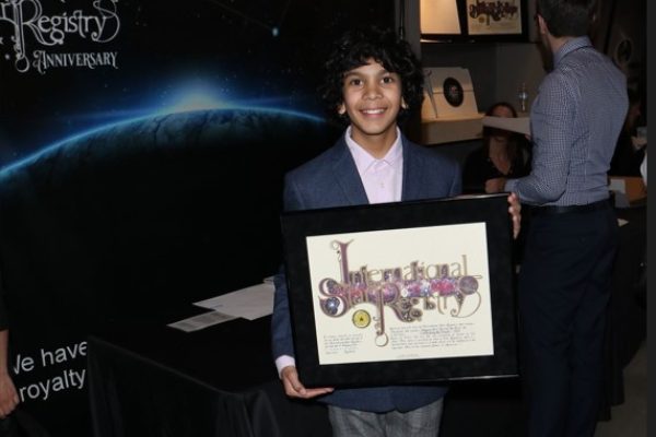 Gustavo Quiroz holding his name a star certificate from starregistry.com