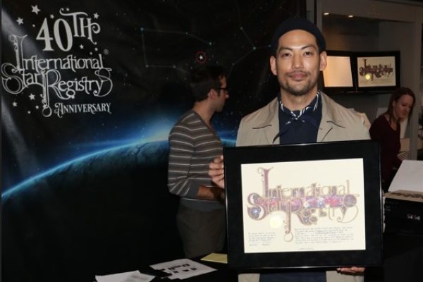 Joseph Lee holding his name a star certificate from starregistry.com