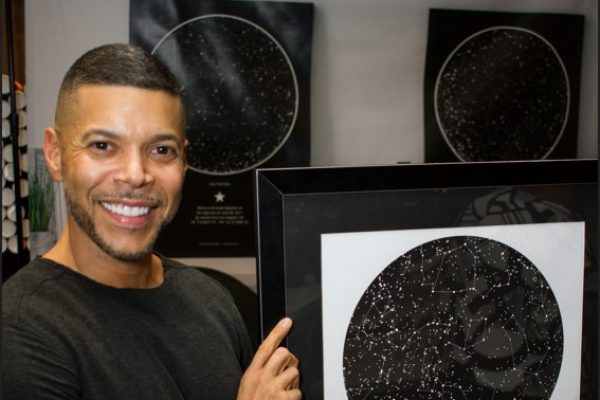 Wilson Cruz holding a sky map from International Star Registry